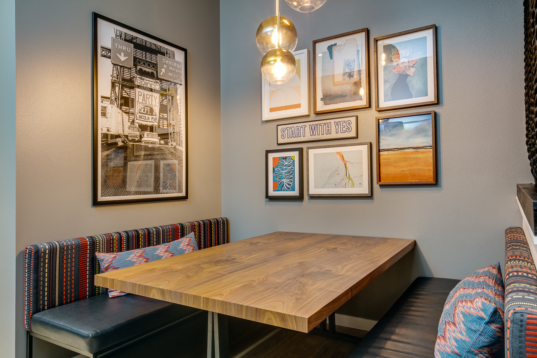a dining room with pictures on the wall and a wooden table