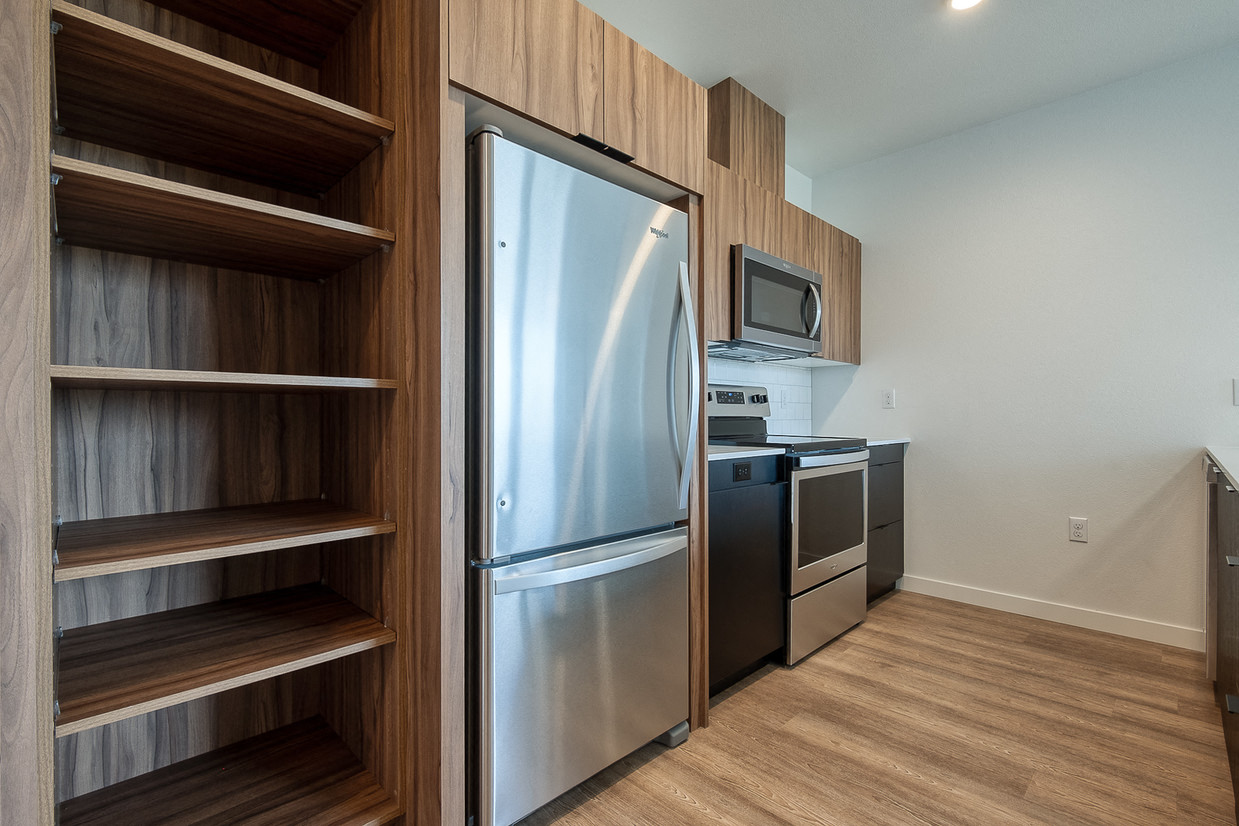 a kitchen with a stainless steel refrigerator and a wooden cabinet