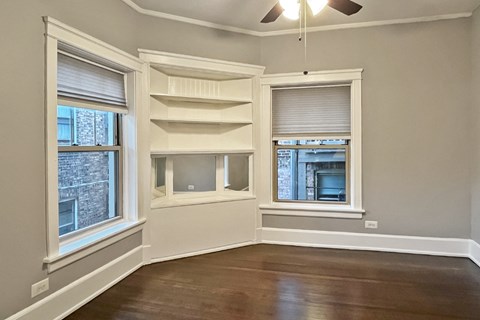 A room with a window and a ceiling fan.