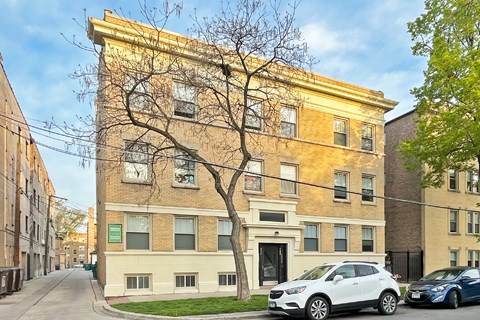 A yellow building with a tree in front of it.