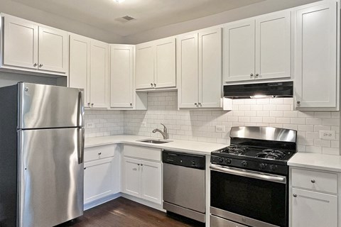 A kitchen with white cabinets and stainless steel appliances.
