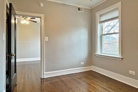 A room with a window and a ceiling fan.