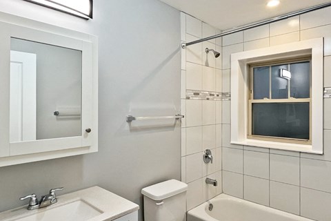 A white bathroom with a toilet, sink, and bathtub.