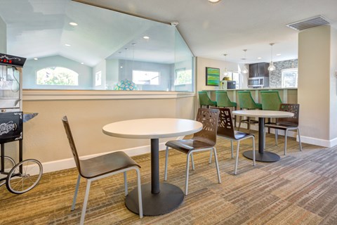 a common area with tables and chairs and a kitchen
