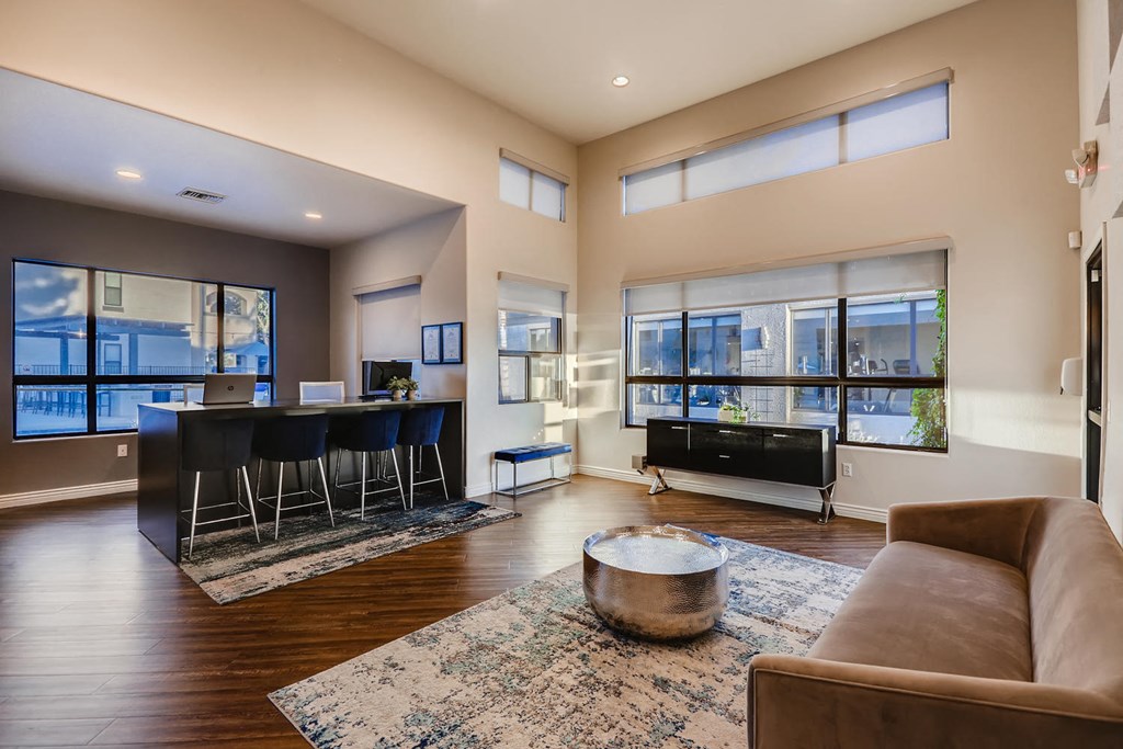 a living room with a couch and a bar and large windows