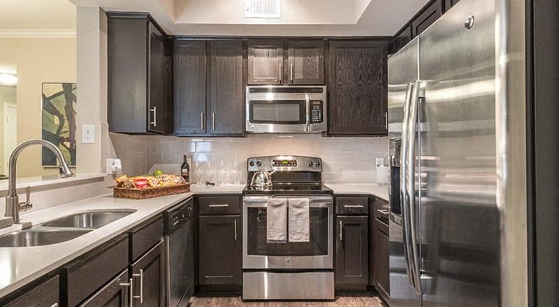 a kitchen with stainless steel appliances and black cabinets