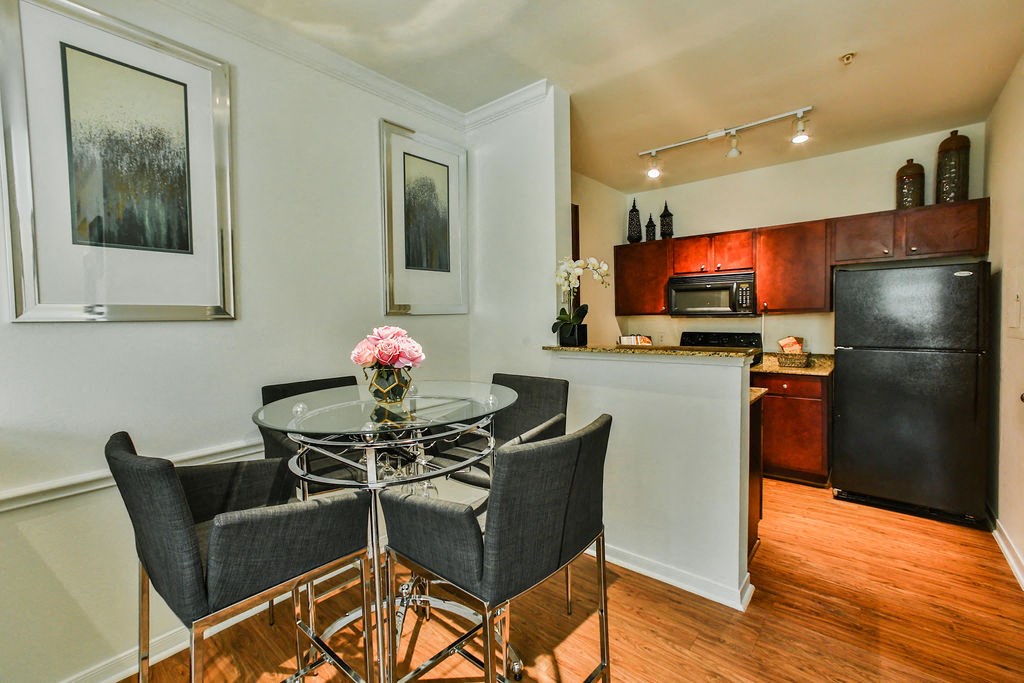 a kitchen and dining room with a glass table and chairs