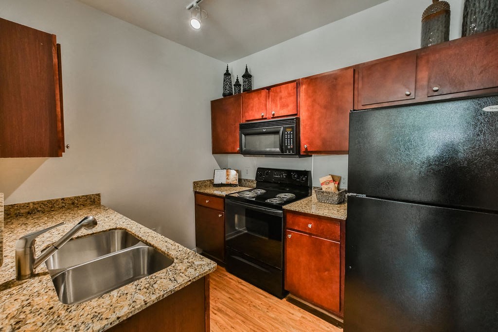a kitchen with black appliances and granite counter tops