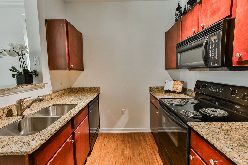 a kitchen with a sink and a stove and a microwave