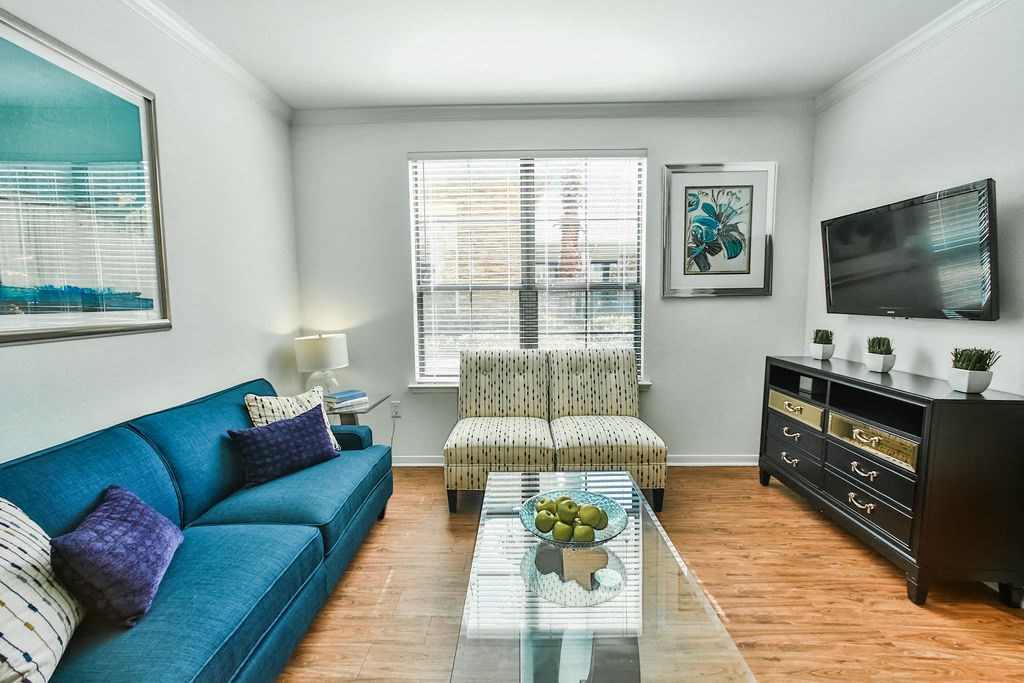 a living room with a blue couch and a television