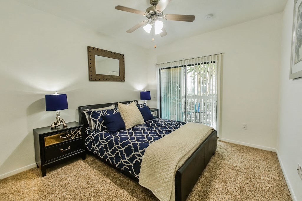 a bedroom with a bed and a ceiling fan