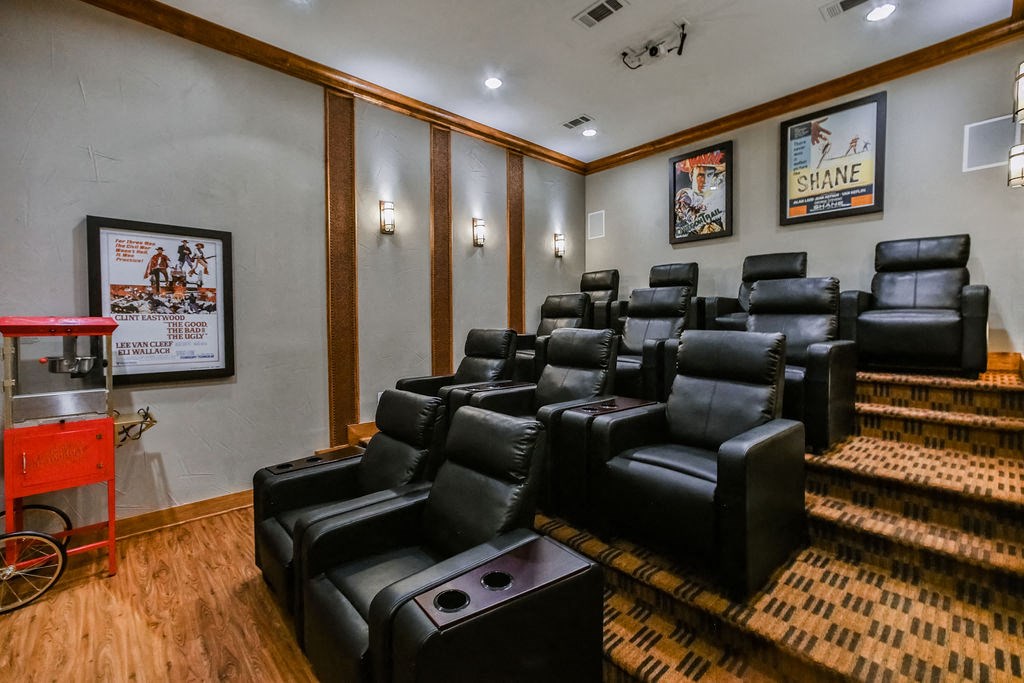 a theater room with leather chairs and a projector screen