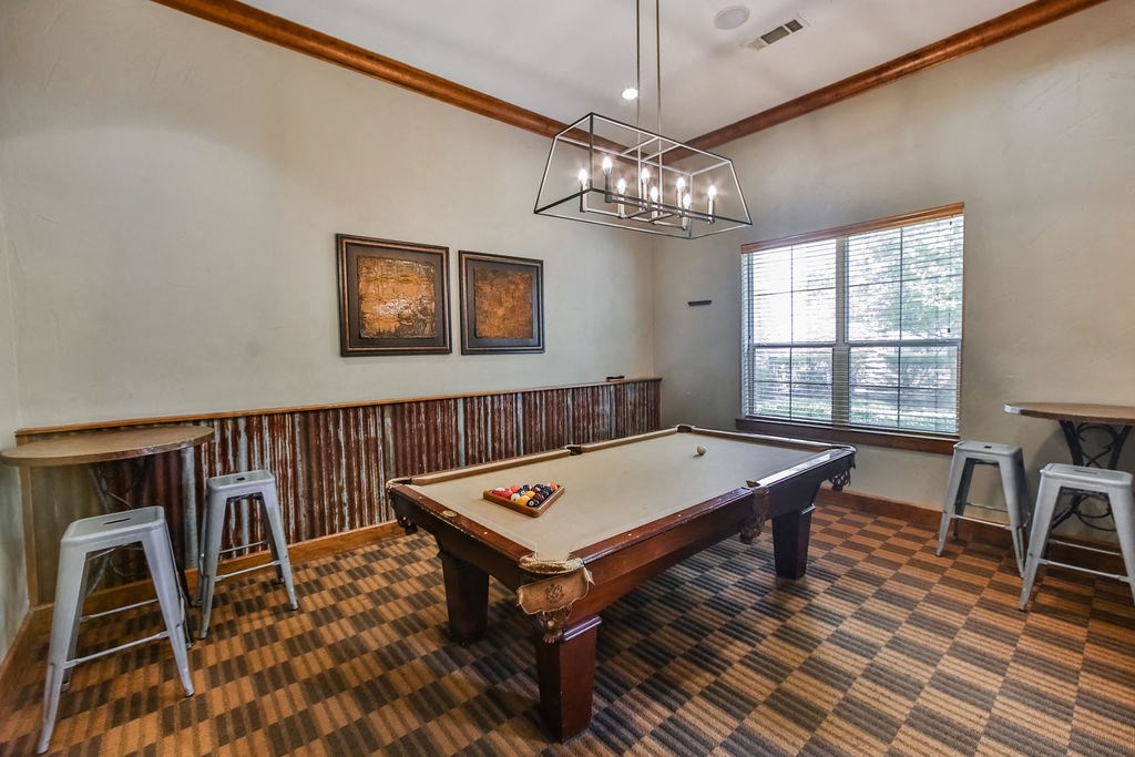 a game room with a pool table and bar