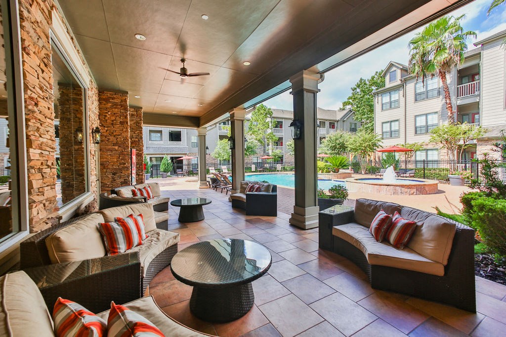a patio with couches and tables and a pool