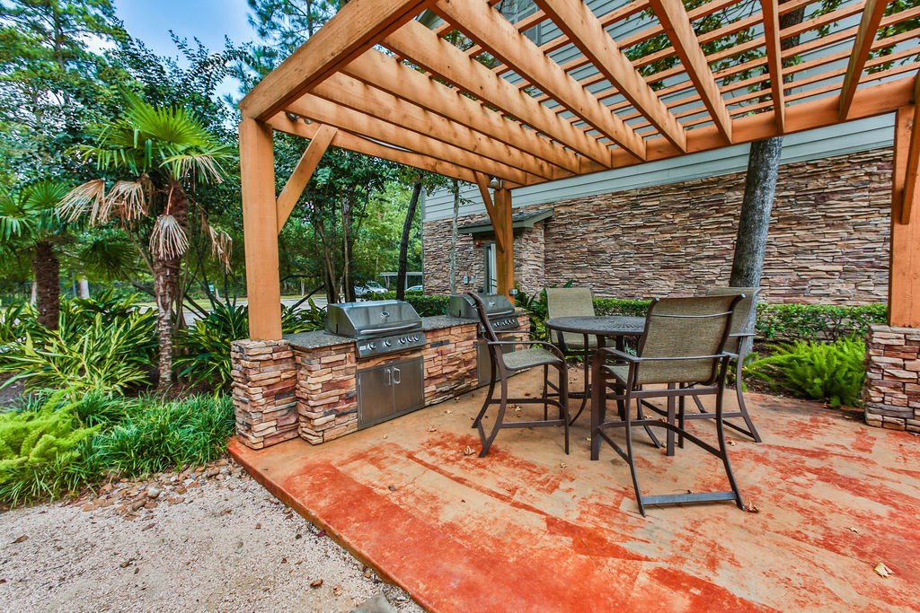 a patio with a table and chairs and a grill