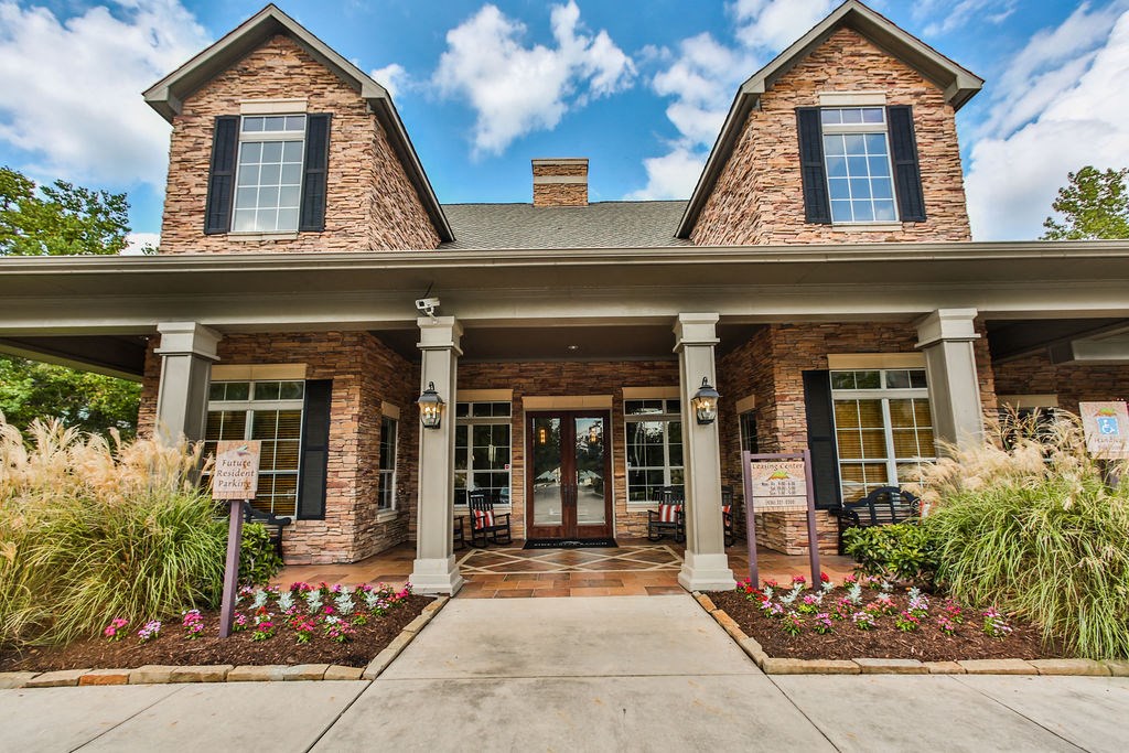 the front entrance of a brick house with a sidewalk and a porch