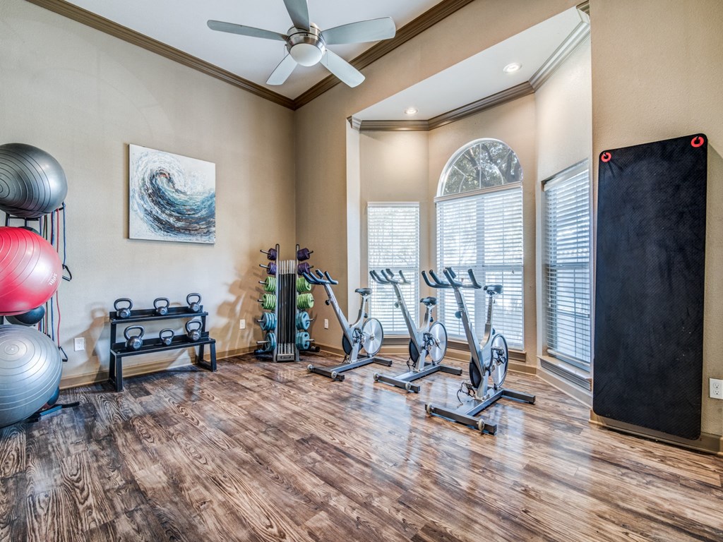 the gym has plenty of exercise equipment and a large window