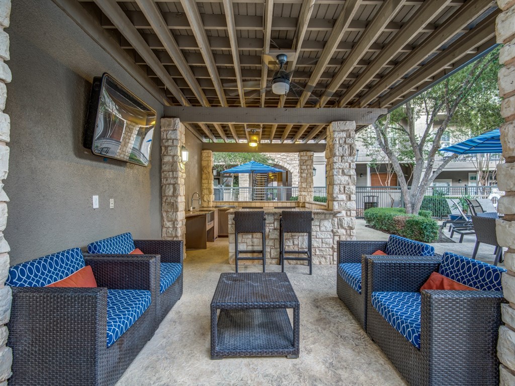 a covered patio with furniture and a bar