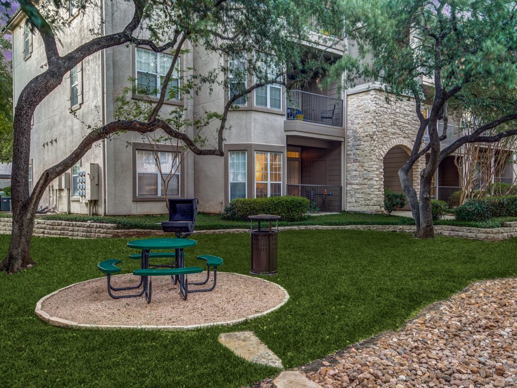 our apartments have a small courtyard with a picnic table and a trash can