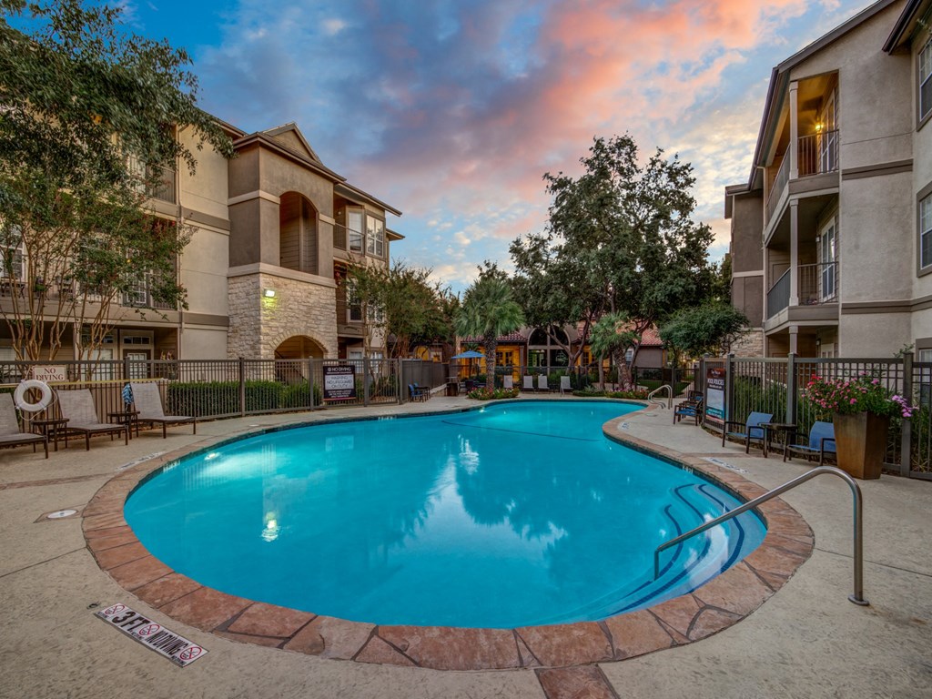 a large swimming pool with an apartment building in the background