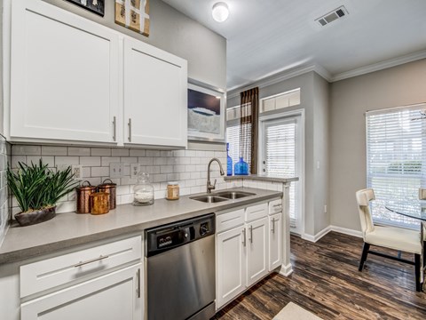 the kitchen of a home with white cabinets and a sink