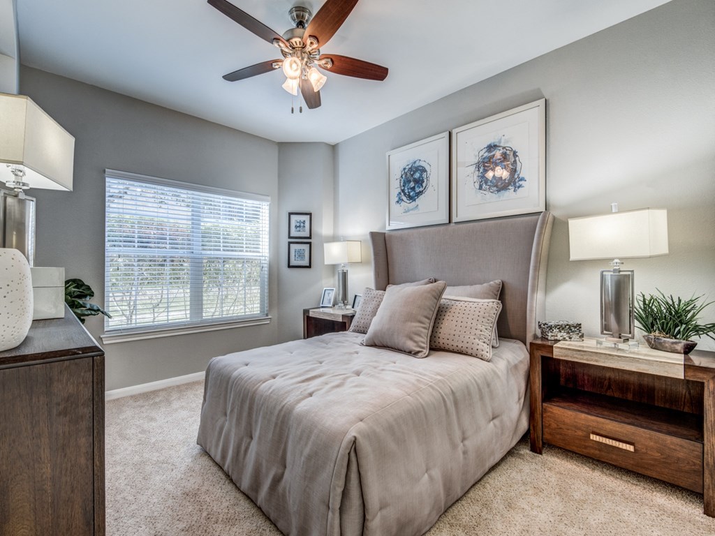 a bedroom with a large bed and a ceiling fan