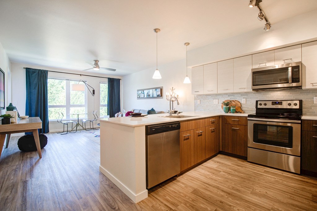 Kitchen with Wood Inspired Floor, Oven, Stove, Microwave, Dishwasher and View of Living Room