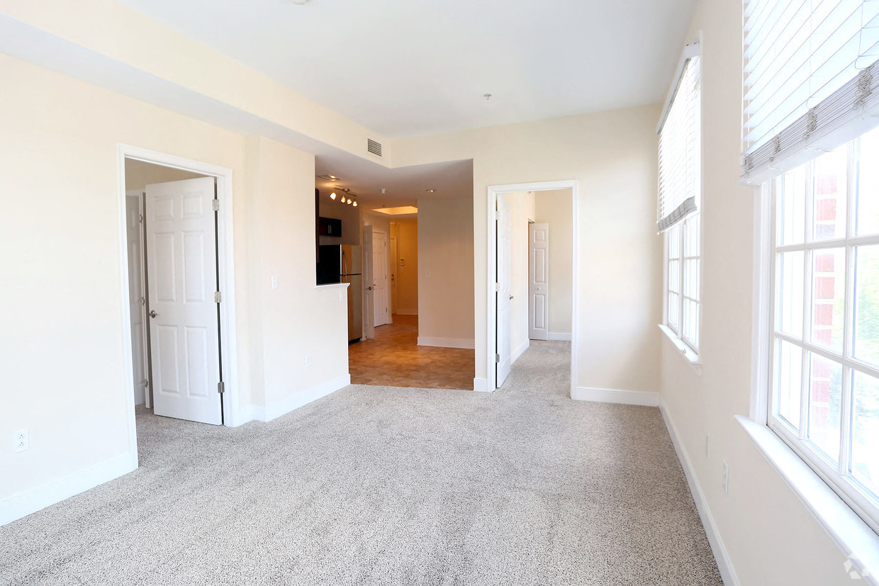 an empty living room with white walls and a carpeted floor