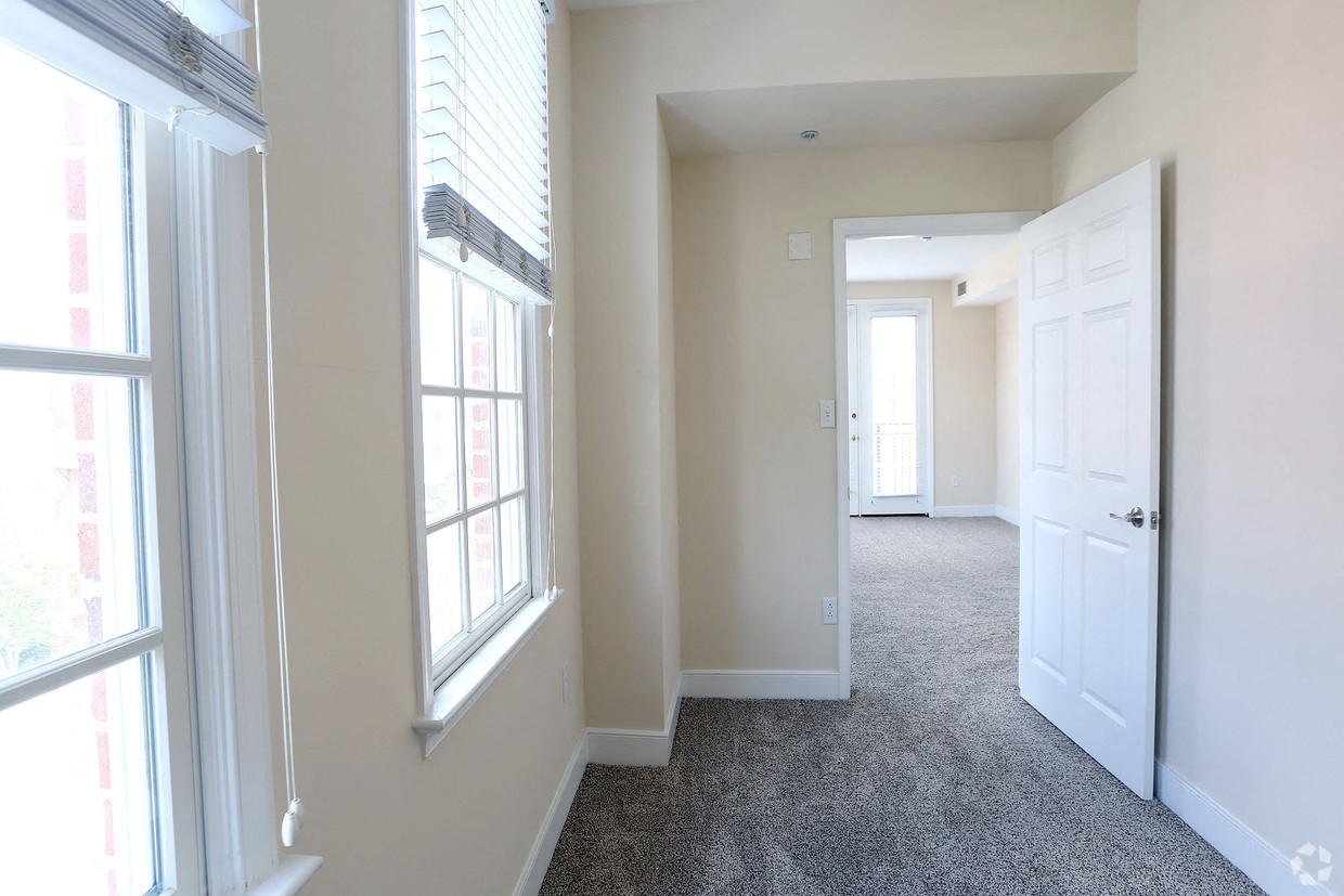 an empty hallway with windows and a white door