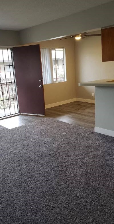 an empty living room with a door to a balcony
