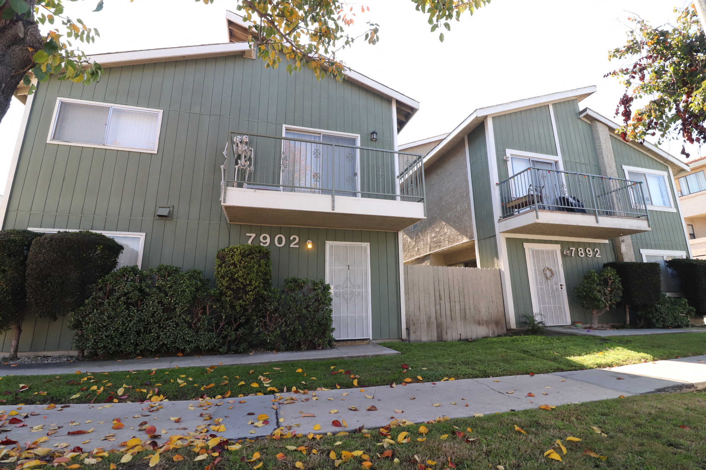 the exterior of an apartment building with a sidewalk