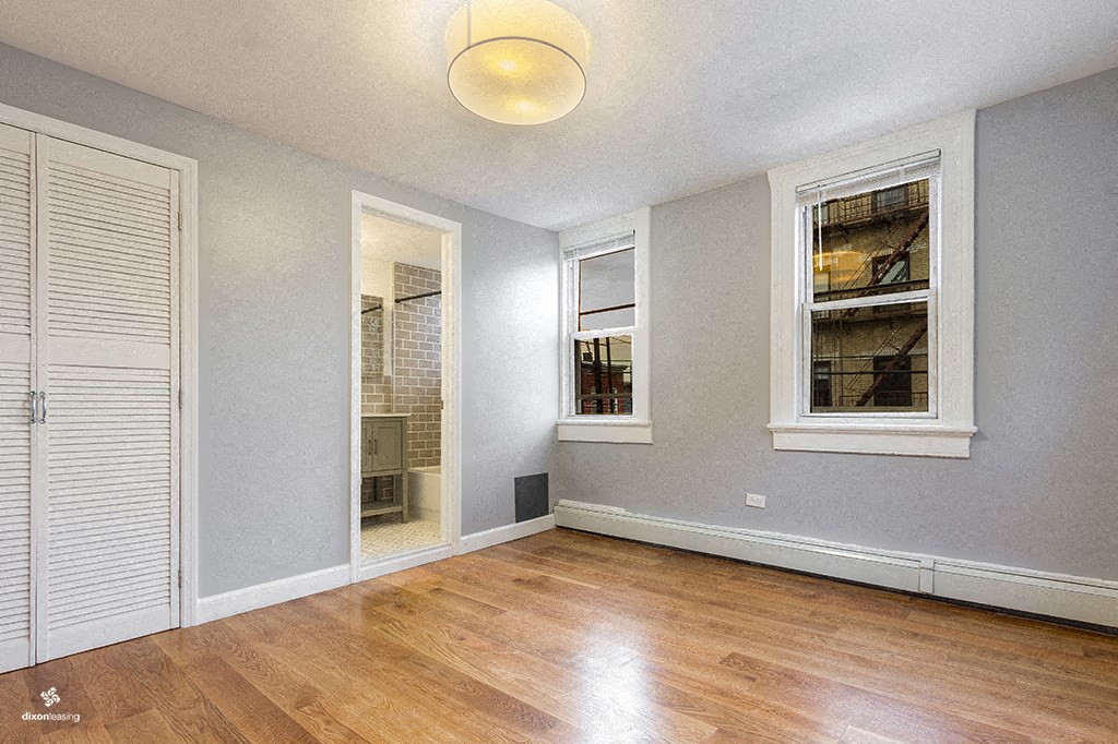 an empty living room with wood flooring and windows