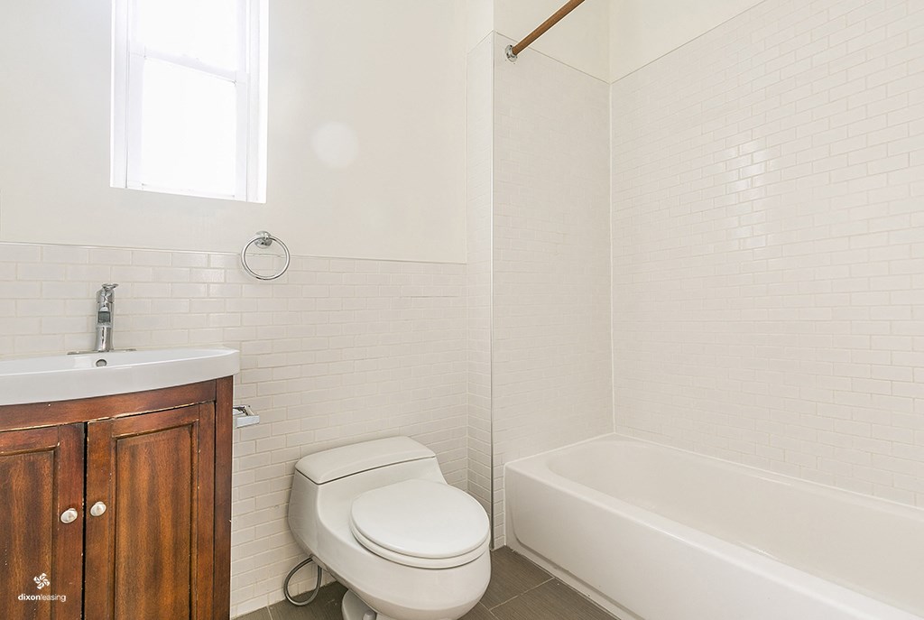 a bathroom with a white toilet and a tub and a sink
