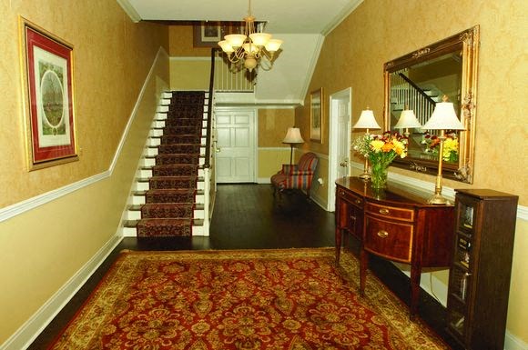a living room with a dresser and a staircase