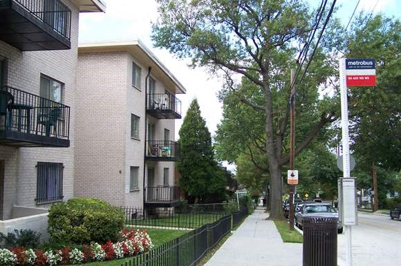 an apartment building on the side of a sidewalk