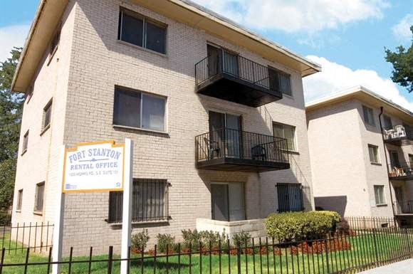 an apartment building with a sign in front of it