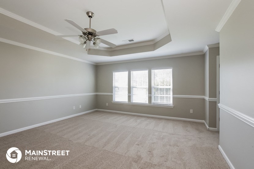 an empty room with a ceiling fan and a window