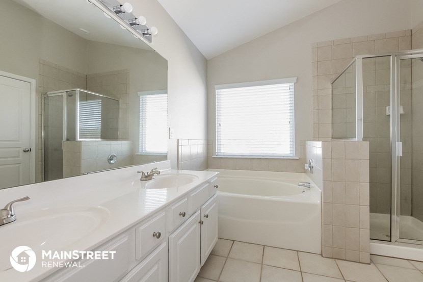 a white bathroom with two sinks and a tub and a shower