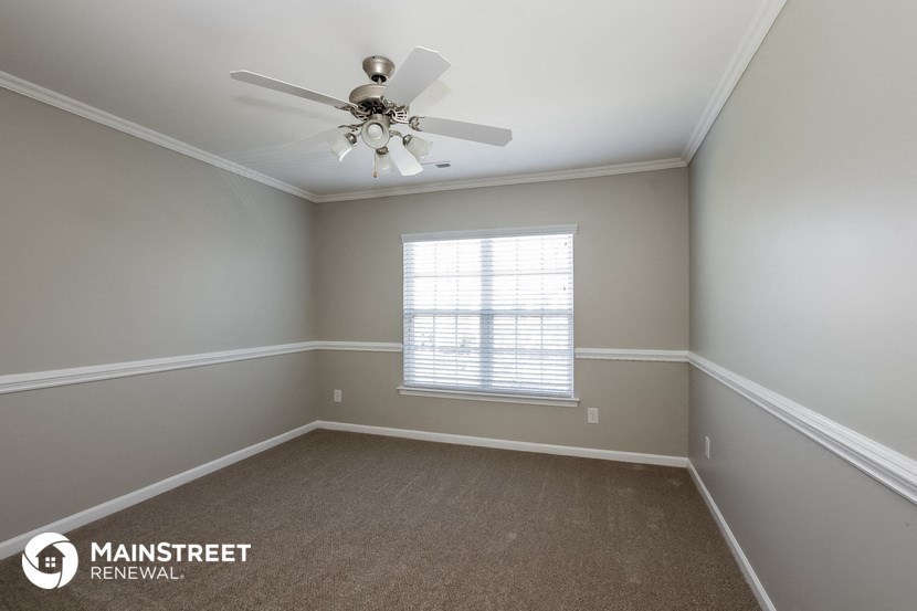 an empty room with a ceiling fan and a window