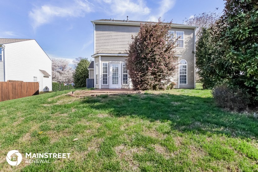 a home with a lawn and a house in the background