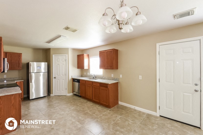 a kitchen with wooden cabinets and a stainless steel refrigerator