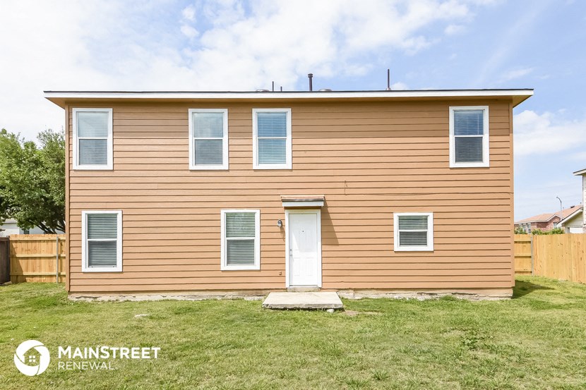 a small house with brown siding and a white door
