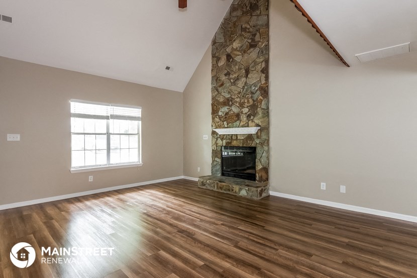the living room has a fireplace and hardwood floors