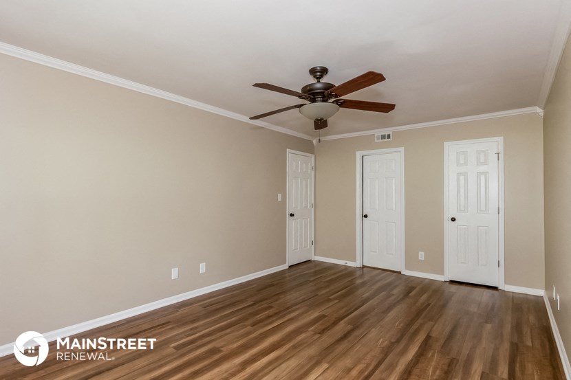 the living room of an empty renovated house with a ceiling fan