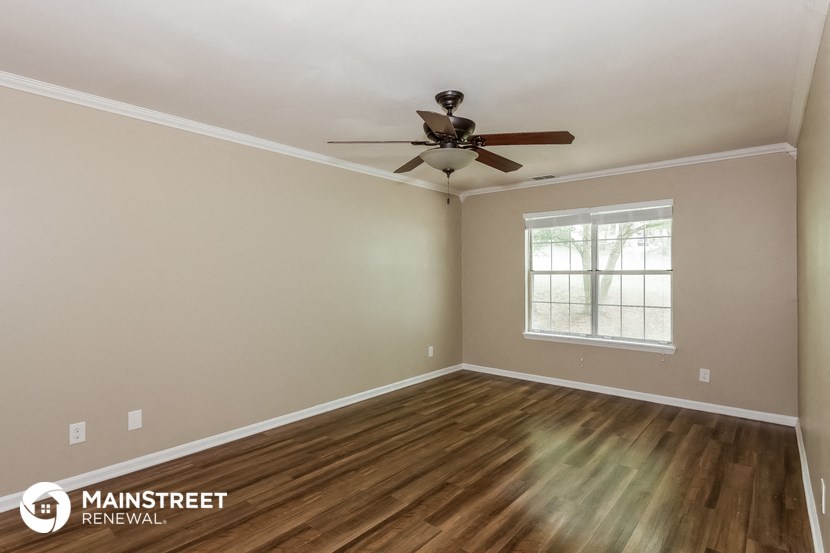 the interior of an empty room with a ceiling fan