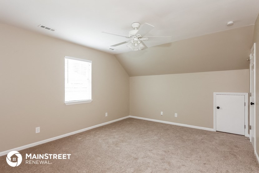 a bedroom with carpet and a ceiling fan