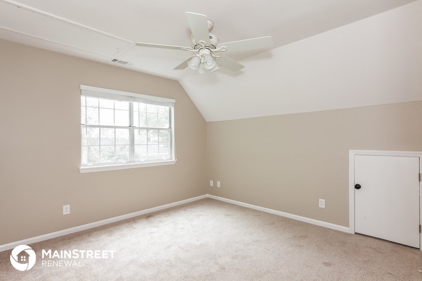 a master bedroom with carpet and a ceiling fan