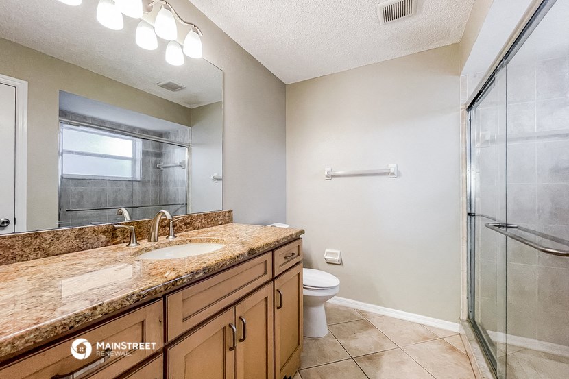a bathroom with a sink and a shower and a toilet