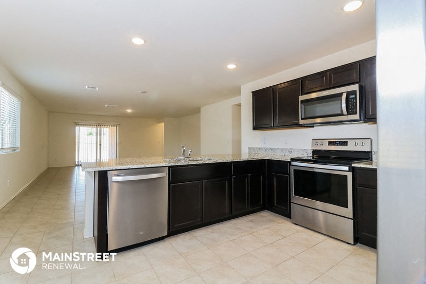 a large kitchen with black cabinets and stainless steel appliances