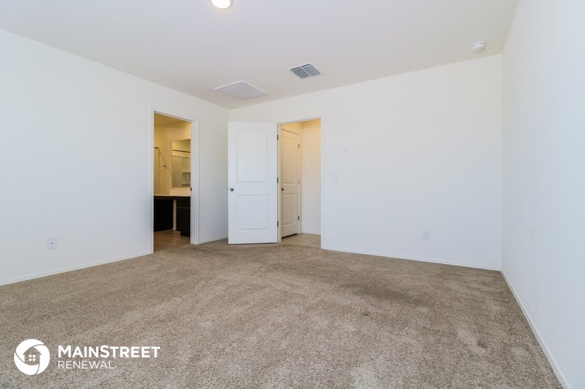 the spacious living room with carpeting and white walls